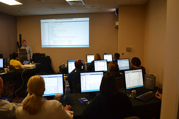 businesspersons watching a technology demonstration on a computer during a break out session